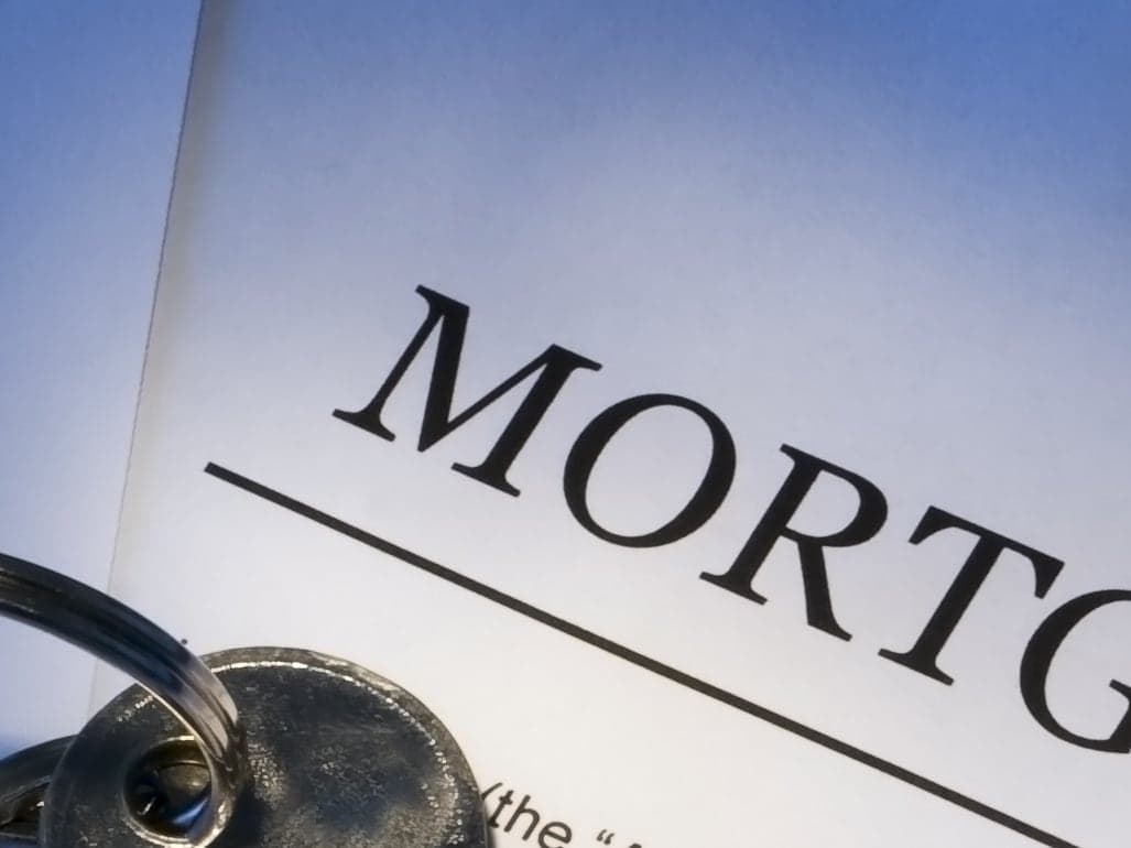 A keyring resting on the title page of a mortgage contract.